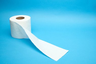 Minimalist mavi arka planda beyaz tuvalet kağıdı rulosu yırtılmış