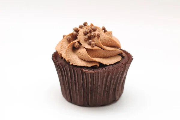 Cupcake de chocolate isolado com topo de creme e cobertura crocante em um fundo branco — Fotografia de Stock