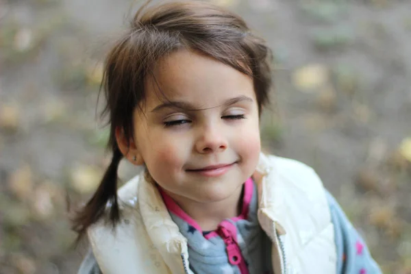 Sourire fille blanche avec des queues de cheval dans un gilet blanc avec les yeux fermés — Photo