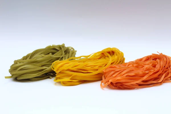 Nidi di spaghetti colorati isolati su sfondo bianco . — Foto Stock