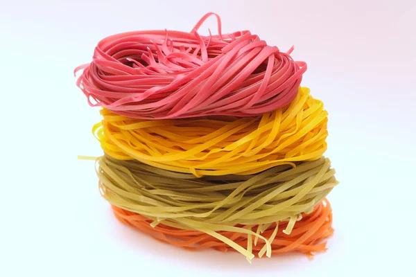 Nidi di spaghetti colorati isolati su sfondo bianco . — Foto Stock