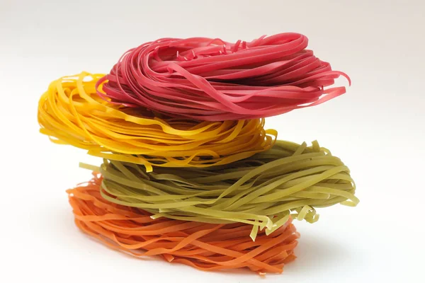 Nidi di spaghetti colorati isolati su sfondo bianco . — Foto Stock