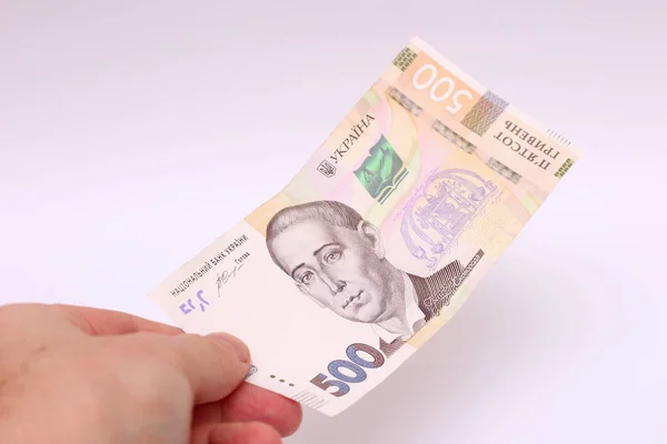 Billete de 500 hryvnia en mano masculina sobre fondo blanco. Dar un soborno en Ucrania. Cambio de moneda europeo. Ucrania moneda — Foto de Stock