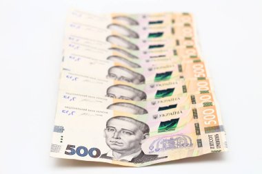 A lot of new banknotes in denominations of 500 Ukrainian hryvnias isolated on a white background with shadow. European money exchange. Ukraine currency. Selective focus