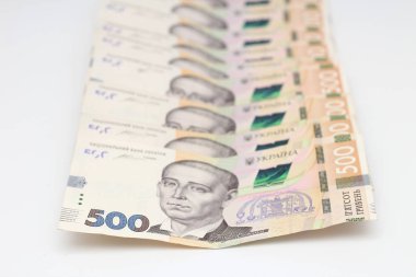 A lot of new banknotes in denominations of 500 Ukrainian hryvnias isolated on a white background with shadow. European money exchange. Ukraine currency. Selective focus