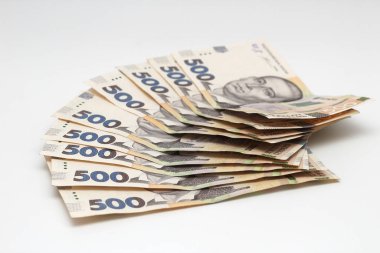 A lot of new banknotes in denominations of 500 Ukrainian hryvnias isolated on a white background with shadow. European money exchange. Ukraine currency. Selective focus