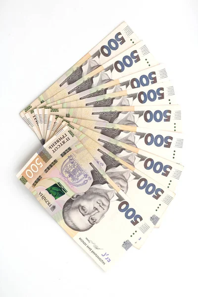 A lot of new banknotes in denominations of 500 Ukrainian hryvnias isolated on a white background with shadow. European money exchange. Ukraine currency. Selective focus