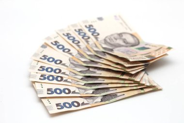 A lot of new banknotes in denominations of 500 Ukrainian hryvnias isolated on a white background with shadow. European money exchange. Ukraine currency. Selective focus