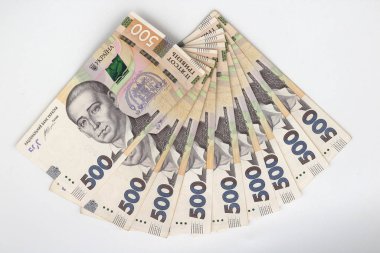 A lot of new banknotes in denominations of 500 Ukrainian hryvnias isolated on a white background with shadow. European money exchange. Ukraine currency. Selective focus