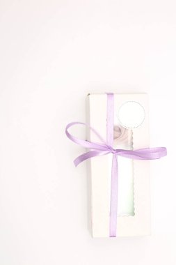 White cardboard box with a transparent top tied with a lilac ribbon isolated on a white background. A wonderful gift for Valentine's Day, birthday.