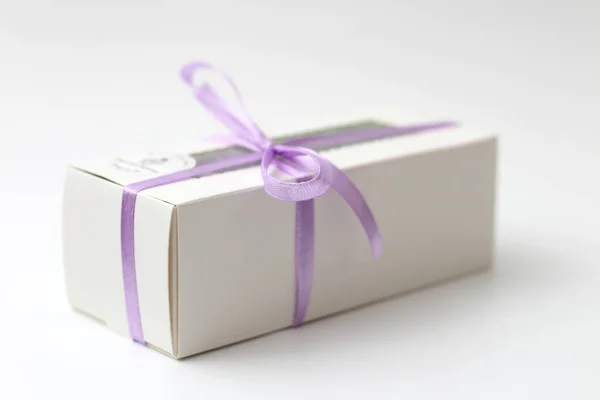 White cardboard box with a transparent top tied with a lilac ribbon isolated on a white background. A wonderful gift for Valentine's Day, birthday. — Stok fotoğraf