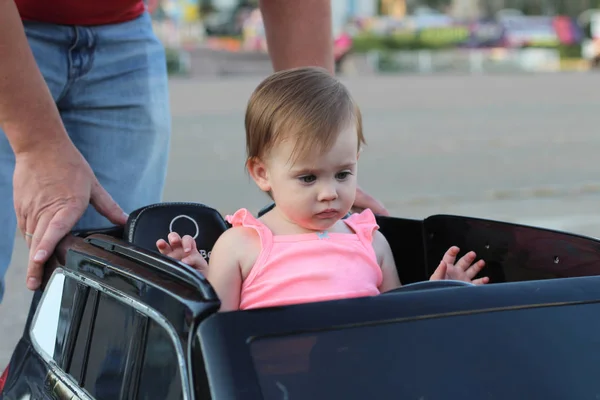 Niña Hace Gesto Indefenso Mientras Está Sentada Gran Coche Juguete —  Fotos de Stock