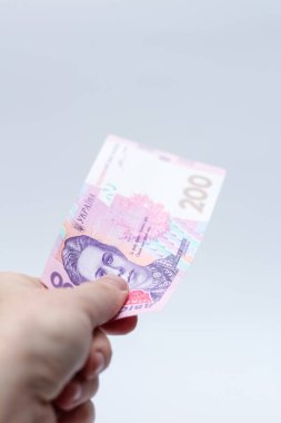 Beyaz arka planda bir erkeğin elinde 200 Hryvnia banknotu. Ukrayna 'da rüşvet vermek. Avrupa para değişimi. Ukrayna para birimi