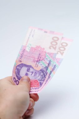 Beyaz arka planda bir erkeğin elinde 200 Hryvnia banknotu. Ukrayna 'da rüşvet vermek. Avrupa para değişimi. Ukrayna para birimi