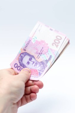 Beyaz arka planda bir erkeğin elinde 200 Hryvnia banknotu. Ukrayna 'da rüşvet vermek. Avrupa para değişimi. Ukrayna para birimi