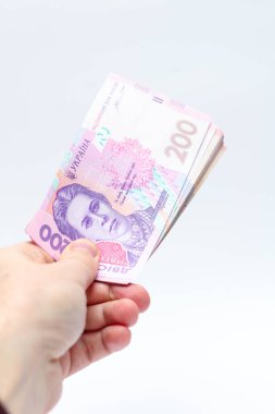 Beyaz arka planda bir erkeğin elinde 200 Hryvnia banknotu. Ukrayna 'da rüşvet vermek. Avrupa para değişimi. Ukrayna para birimi