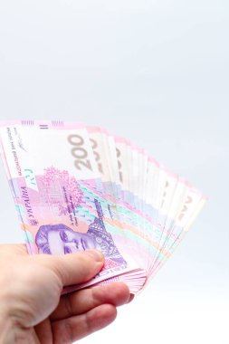 Beyaz arka planda bir erkeğin elinde 200 Hryvnia banknotu. Ukrayna 'da rüşvet vermek. Avrupa para değişimi. Ukrayna para birimi