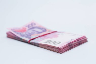 200 Ukrayna Hrivniası 'na ait banknotlarda bir sürü yeni banknot ve gölgeli beyaz bir arka planda izole edilmiş elastik bant var. Avrupa para değişimi. Ukrayna parası. Seçici odak