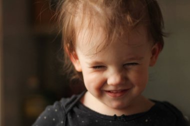 Yumuşak ışık ve bulanık arka planda kirli bir yüzü olan küçük, beyaz bir bebeğin yakın plan portresi.