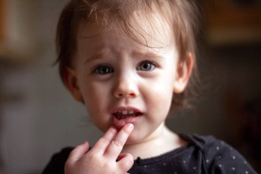 Yumuşak ışık ve bulanık arka planda kirli bir yüzü olan küçük, beyaz bir bebeğin yakın plan portresi.