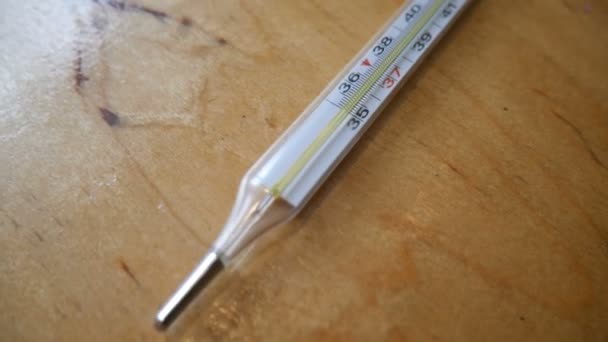 Стеклянный ртутный термометр измеряет температуру — стоковое видео