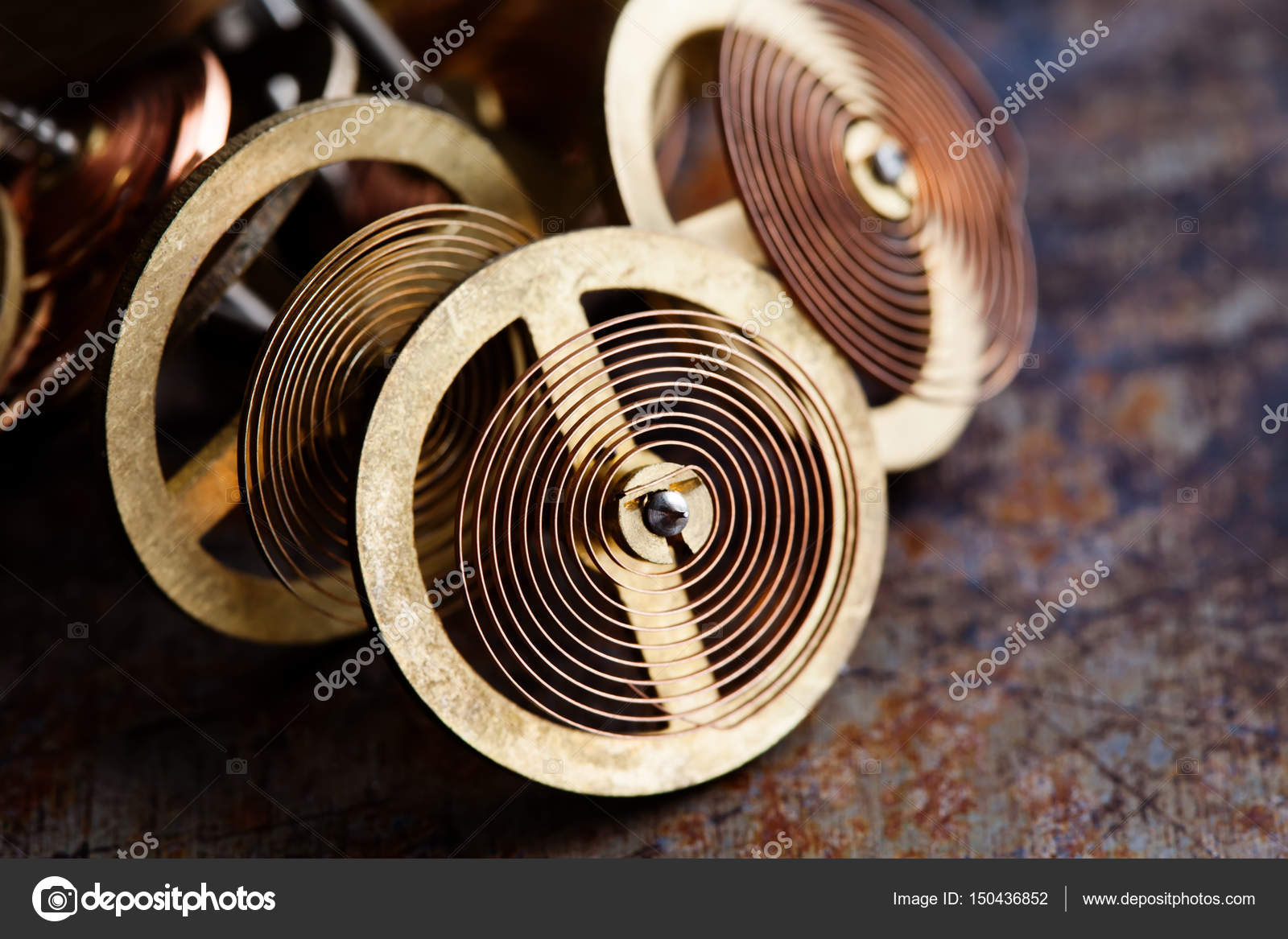 Vintage clockwork wheels with spring mechanism. Brass gears cogs on