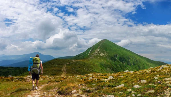 A tourist with a large backpack rises to Goverla mountain in Carpathian mountains Ukraine — Stock Photo, Image