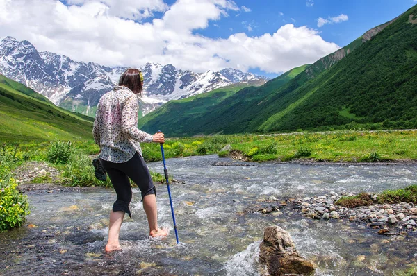 Young girl crossing mountain river barefoot — Stock Photo, Image