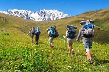 Büyük sırt çantaları turistlerle gruptur dağda