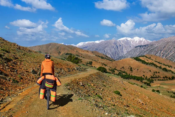 Un hombre en bicicleta con una gran mochila monta en un camino de montaña Turquía — Foto de Stock