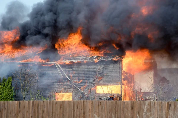 House burning on fire. Building covered by flame. Flaming wooden construction.