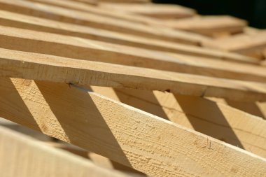 Tahta inşaat alanında toplanmış. Binanın yeni yapısı. Doğal malzemelerden yapılmış iskelet iskeleti. Ahşap zemin ya da tavan. İnşaatın elementleri ve bileşenleri.