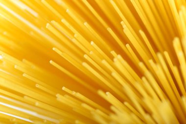 Uzun sarı spagetti makarna malzemesi. Pişmemiş kuru makarna. İnce çiğ erişte. Lezzetli gurme yemekleri için tahıl ürünleri. Yararlı bir karbonhidrat kaynağı. Sağlıklı İtalyan makarnası.