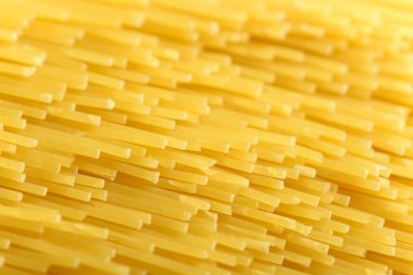 Uzun sarı spagetti makarna malzemesi. Pişmemiş kuru makarna. İnce çiğ erişte. Lezzetli gurme yemekleri için tahıl ürünleri. Yararlı bir karbonhidrat kaynağı. Sağlıklı İtalyan makarnası.