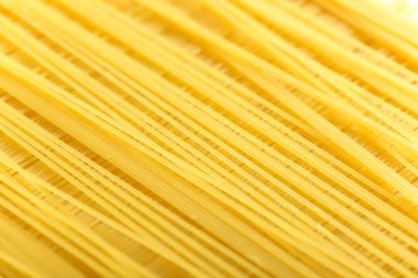 Uzun sarı spagetti makarna malzemesi. Pişmemiş kuru makarna. İnce çiğ erişte. Lezzetli gurme yemekleri için tahıl ürünleri. Yararlı bir karbonhidrat kaynağı. Sağlıklı İtalyan makarnası.
