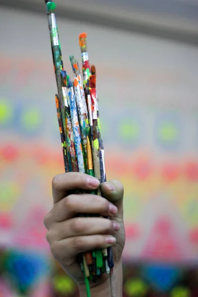 Mão humana segurando escovas de arte — Fotografia de Stock