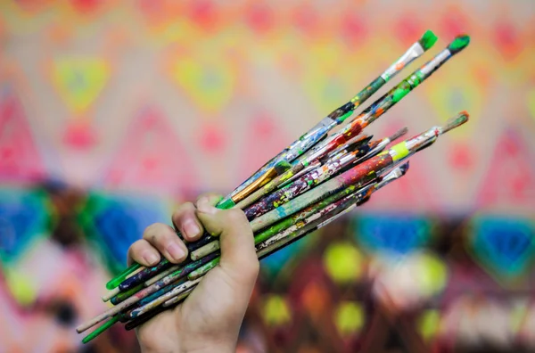 Mão humana segurando escovas de arte — Fotografia de Stock