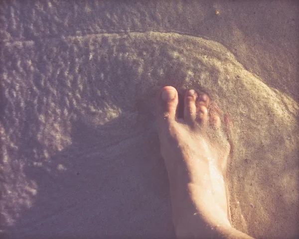 Mänsklig fot på stranden sand — Stockfoto