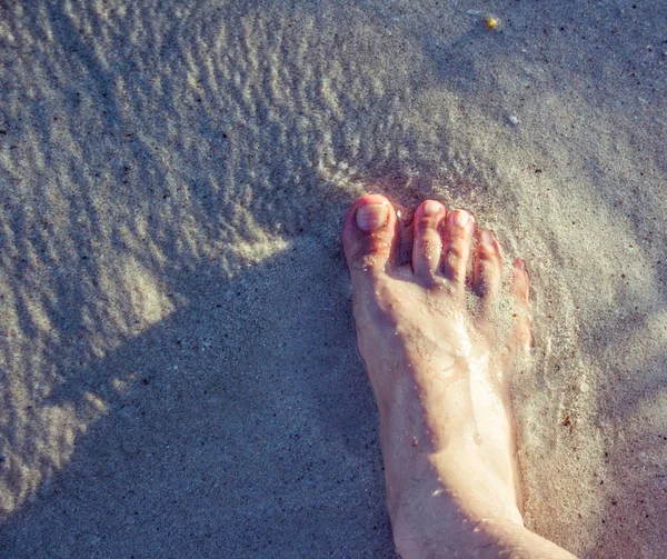 Human foot on beach sand — Stock Photo, Image