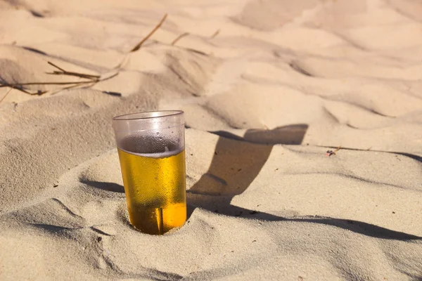 Copo de cerveja na areia da praia — Fotografia de Stock