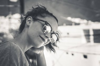 Genç modern gülümseyen kadın güneş gözlüğü ve rahat ifade