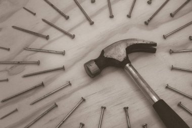 Tahta arka planda çekiç ve çiviler