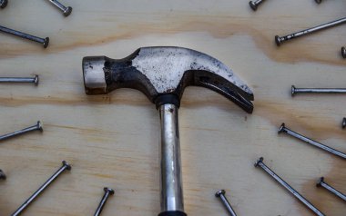 Tahta arka planda çekiç ve çiviler