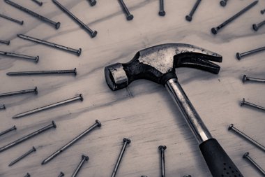 Tahta arka planda çekiç ve çiviler