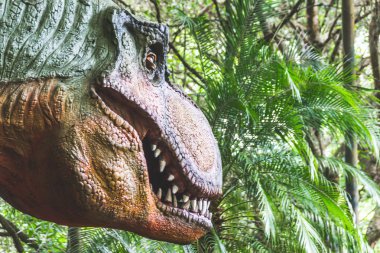 Bir Mekatronik dinozor bir ormanlık alanda doğru profil portresi