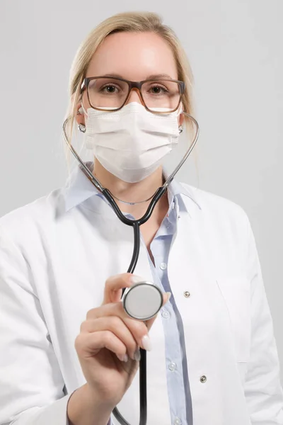 Young female doctor with stethoscope and medical face mask — Stock Photo, Image