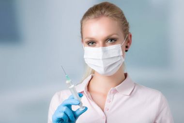 genç kadın doktor enjeksiyon iğne ve medica yüz maskesi