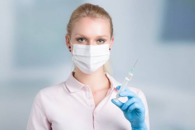 genç kadın doktor enjeksiyon iğne ve medica yüz maskesi