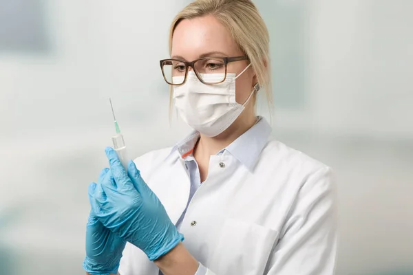 Estudante de medicina com uma seringa com clínica em segundo plano — Fotografia de Stock