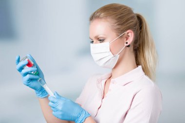 nurse pulls up a syringe with clinic in background clipart
